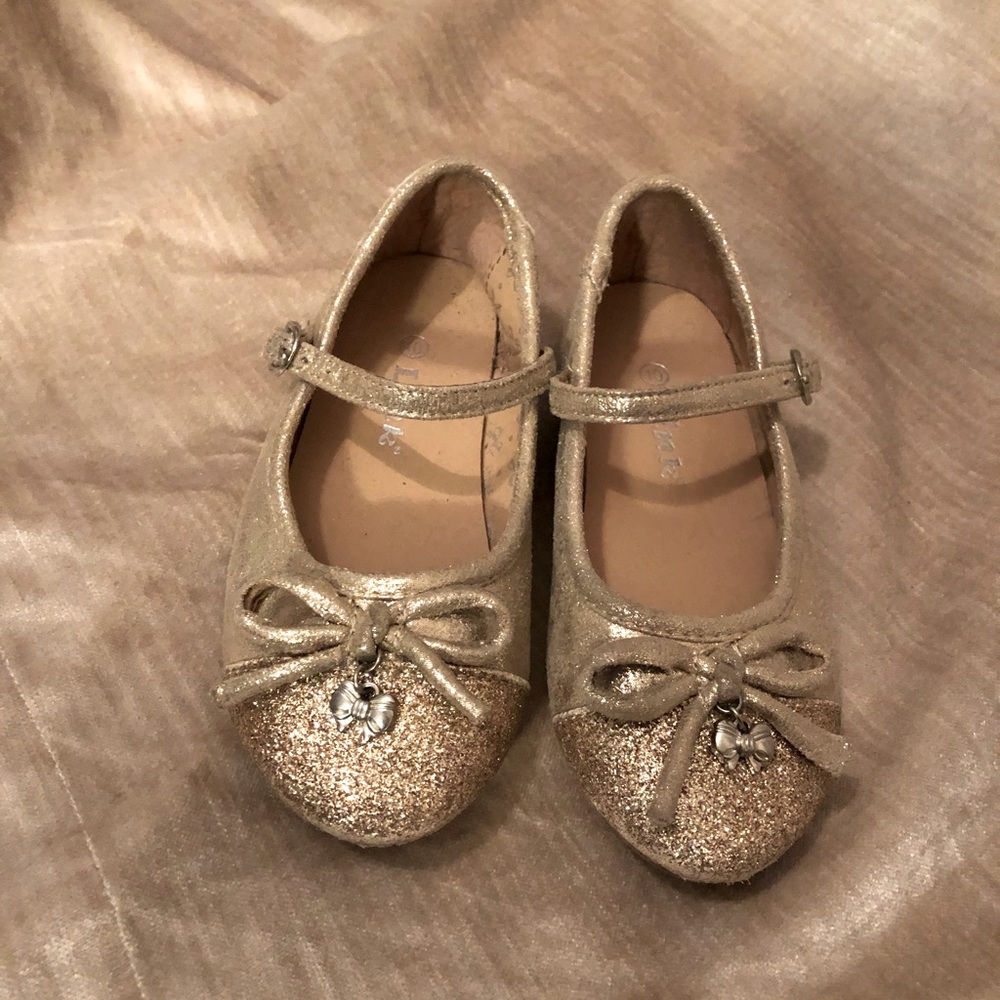 Gold Mary-Jane girl’s dress shoes with removable silver charm.
